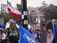 Veiled women are waving the flag of the Islamic Revolutionary Guard Corps and holding a portrait of Iran's Supreme Leader, Ayatollah Ali Kha...