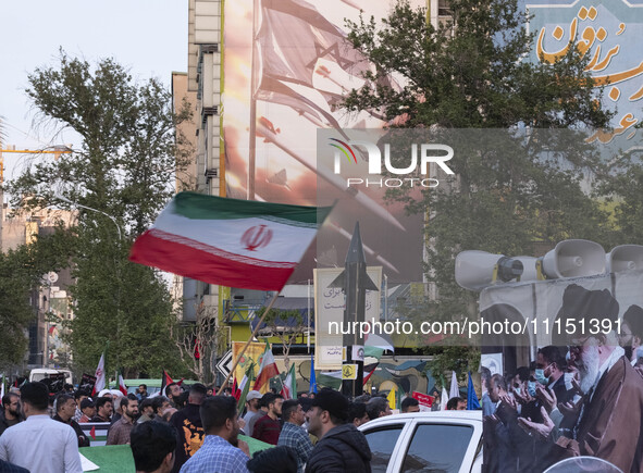 A man is waving an Iranian flag next to a model of Iran's first-ever hypersonic missile, Fattah, under an anti-Israeli mural during a gather...