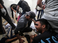 Palestinians are mourning the death of loved ones following an Israeli bombardment in Maghazi in the central Gaza Strip, on April 16, 2024,...