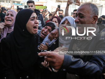 Palestinians are reacting next to their relatives who have been killed in an Israeli strike as they arrive at Al-Aqsa hospital, amid the ong...