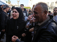 Palestinians are reacting next to their relatives who have been killed in an Israeli strike as they arrive at Al-Aqsa hospital, amid the ong...