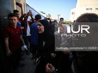 Palestinians are reacting next to their relatives who have been killed in an Israeli strike as they arrive at Al-Aqsa hospital, amid the ong...