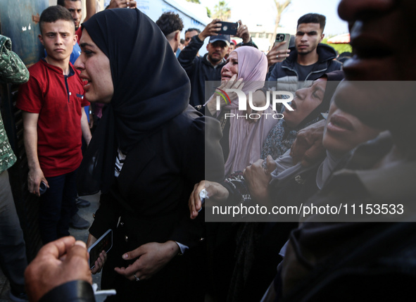 Palestinians are reacting next to their relatives who have been killed in an Israeli strike as they arrive at Al-Aqsa hospital, amid the ong...