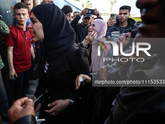 Palestinians are reacting next to their relatives who have been killed in an Israeli strike as they arrive at Al-Aqsa hospital, amid the ong...