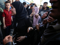 Palestinians are reacting next to their relatives who have been killed in an Israeli strike as they arrive at Al-Aqsa hospital, amid the ong...