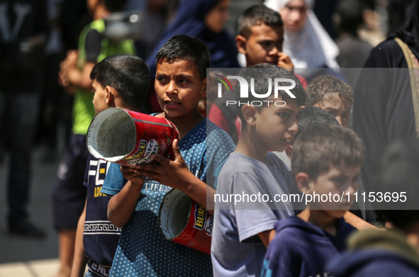 Displaced Palestinians are gathering to receive food at a donation point in Deir al-Balah, central Gaza Strip, on April 16, 2024, amid ongoi...