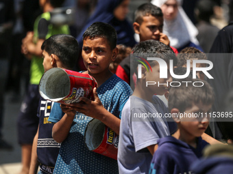 Displaced Palestinians are gathering to receive food at a donation point in Deir al-Balah, central Gaza Strip, on April 16, 2024, amid ongoi...