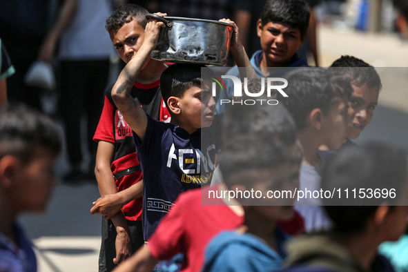 Displaced Palestinians are gathering to receive food at a donation point in Deir al-Balah, central Gaza Strip, on April 16, 2024, amid ongoi...