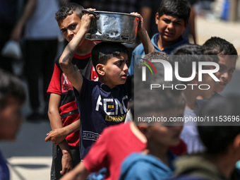 Displaced Palestinians are gathering to receive food at a donation point in Deir al-Balah, central Gaza Strip, on April 16, 2024, amid ongoi...