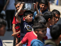 Displaced Palestinians are gathering to receive food at a donation point in Deir al-Balah, central Gaza Strip, on April 16, 2024, amid ongoi...