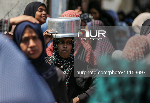 Displaced Palestinians are gathering to receive food at a donation point in Deir al-Balah, central Gaza Strip, on April 16, 2024, amid ongoi...