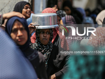 Displaced Palestinians are gathering to receive food at a donation point in Deir al-Balah, central Gaza Strip, on April 16, 2024, amid ongoi...