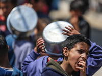 Displaced Palestinians are gathering to receive food at a donation point in Deir al-Balah, central Gaza Strip, on April 16, 2024, amid ongoi...