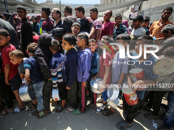 Displaced Palestinians are gathering to receive food at a donation point in Deir al-Balah, central Gaza Strip, on April 16, 2024, amid ongoi...