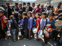 Displaced Palestinians are gathering to receive food at a donation point in Deir al-Balah, central Gaza Strip, on April 16, 2024, amid ongoi...