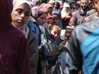 Displaced Palestinians are gathering to receive food at a donation point in Deir al-Balah, central Gaza Strip, on April 16, 2024, amid ongoi...