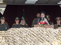 Iranian President Ebrahim Raisi (C) is addressing attendees at a military parade marking Iran's Army Day anniversary at an Army military bas...