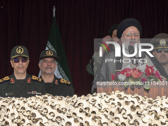 Iranian President Ebrahim Raisi (C) is addressing attendees at a military parade marking Iran's Army Day anniversary at an Army military bas...