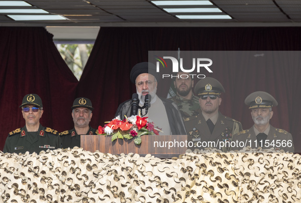 Iranian President Ebrahim Raisi (C) is addressing attendees at a military parade marking Iran's Army Day anniversary at an Army military bas...