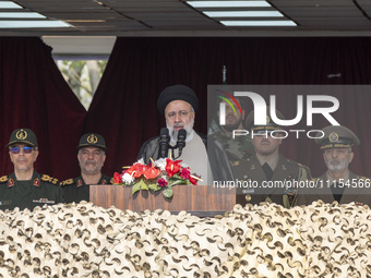 Iranian President Ebrahim Raisi (C) is addressing attendees at a military parade marking Iran's Army Day anniversary at an Army military bas...