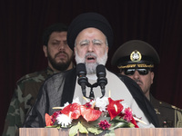 Iranian President Ebrahim Raisi (C) is addressing attendees at a military parade marking Iran's Army Day anniversary at an Army military bas...