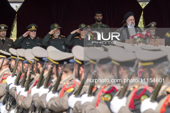 Iranian President Ebrahim Raisi (2nd R) is standing with the Islamic Revolutionary Guard Corps (IRGC) commanders (L) and an Iranian Army com...