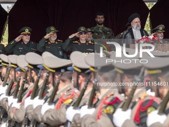 Iranian President Ebrahim Raisi (2nd R) is standing with the Islamic Revolutionary Guard Corps (IRGC) commanders (L) and an Iranian Army com...