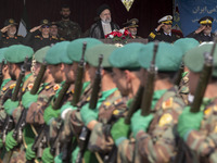 Iranian President Ebrahim Raisi is standing with the Islamic Revolutionary Guard Corps (IRGC) commanders on his left, and Iranian Army comma...