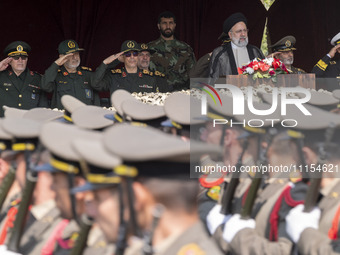 Iranian President Ebrahim Raisi is standing with the Islamic Revolutionary Guard Corps (IRGC) commanders on his left, and Iranian Army comma...