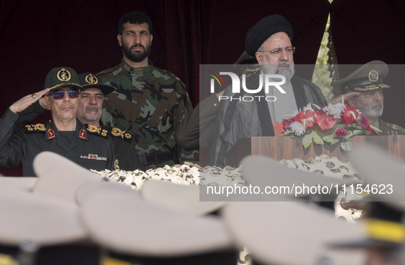 Iranian President Ebrahim Raisi (2nd R) is standing with Islamic Revolutionary Guard Corps (IRGC) commanders (L) and an Iranian Army command...