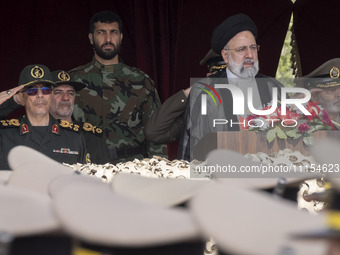 Iranian President Ebrahim Raisi (2nd R) is standing with Islamic Revolutionary Guard Corps (IRGC) commanders (L) and an Iranian Army command...