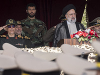 Iranian President Ebrahim Raisi (2nd R) is standing with Islamic Revolutionary Guard Corps (IRGC) commanders (L) and an Iranian Army command...