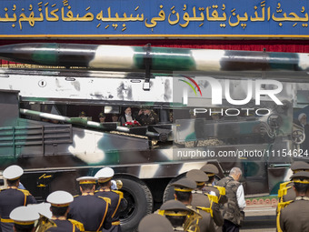 Iranian President Ebrahim Raisi (4th L) is looking at an Iranian missile being carried by a truck while standing with the Islamic Revolution...