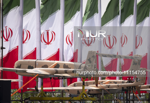 A truck is carrying Iranian-made Unmanned Aerial Vehicles (UAVs) past Iranian flags during a military parade marking the anniversary of Iran...