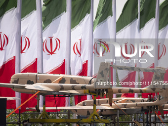 A truck is carrying Iranian-made Unmanned Aerial Vehicles (UAVs) past Iranian flags during a military parade marking the anniversary of Iran...