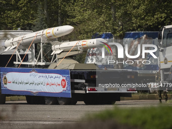 A truck is carrying Iranian-made Sayyad-4B missiles past an anti-Israeli billboard during a military parade marking the anniversary of Iran'...