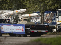 A truck is carrying Iranian-made Sayyad-4B missiles past an anti-Israeli billboard during a military parade marking the anniversary of Iran'...