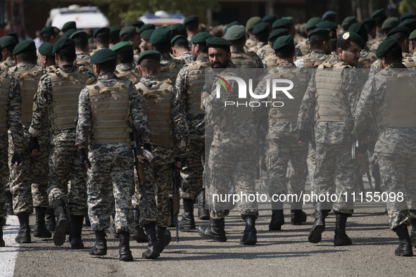 Members of the Iranian Army's land force are walking along an area after marching in a military parade to mark Iran's Army Day anniversary a...