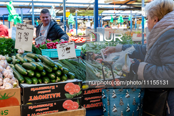 A man sells early vegetables are on a market stand on Old Kleparz Market in Old Town of Krakow as spring gardening season started in Poland...