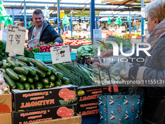 A man sells early vegetables are on a market stand on Old Kleparz Market in Old Town of Krakow as spring gardening season started in Poland...