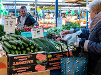 A man sells early vegetables are on a market stand on Old Kleparz Market in Old Town of Krakow as spring gardening season started in Poland...