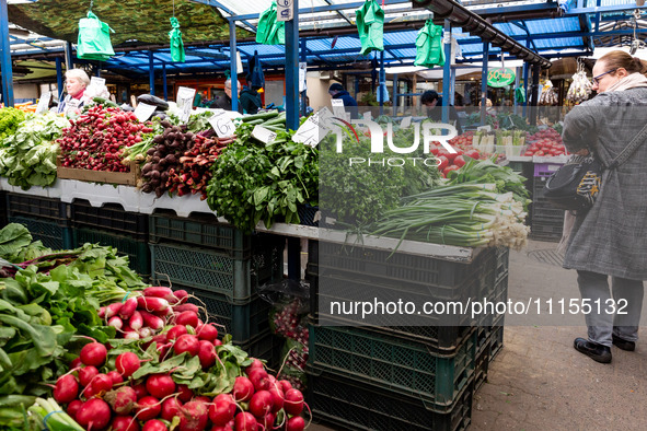 A woman shops for spring vegetables and herbs on Old Kleparz Market in Old Town of Krakow as spring gardening season started in Poland on Ap...