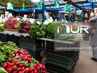 A woman shops for spring vegetables and herbs on Old Kleparz Market in Old Town of Krakow as spring gardening season started in Poland on Ap...