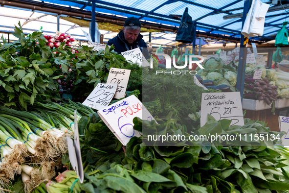 A man sells early vegetables are on a market stand on Old Kleparz Market in Old Town of Krakow as spring gardening season started in Poland...