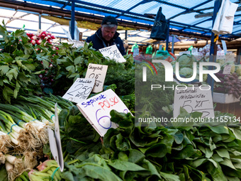 A man sells early vegetables are on a market stand on Old Kleparz Market in Old Town of Krakow as spring gardening season started in Poland...