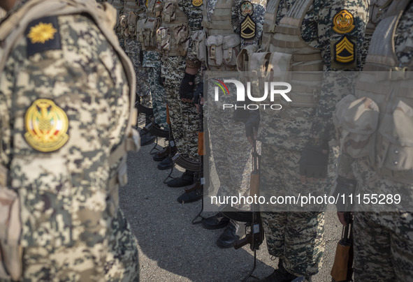 Members of the Iranian Army's land force are standing at attention during a military parade marking the anniversary of Iran's Army Day at an...