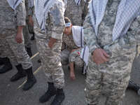 An Iranian schoolboy, who is also a member of the Basij paramilitary force, is looking on while waiting to march in a military parade markin...