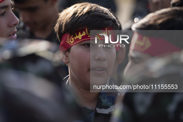 An Iranian schoolboy, who is also a member of the Basij paramilitary force, is preparing to march in a military parade marking Iran's Army D...