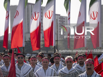 Members of the Basij paramilitary force are posing for a photograph as they prepare to march in a military parade marking Iran's Army Day an...