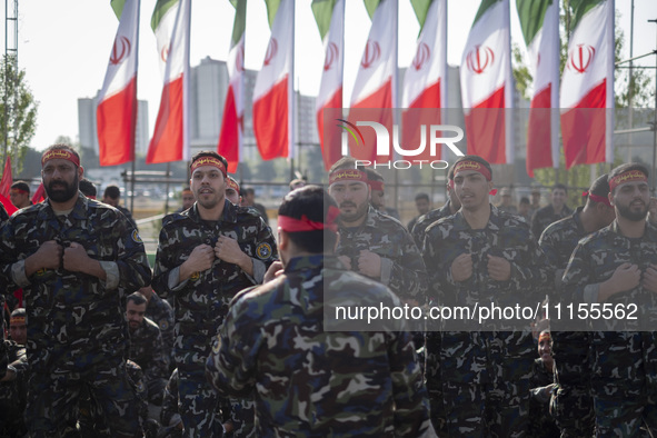 Members of the Basij paramilitary force are preparing to march in a military parade marking Iran's Army Day anniversary at an Army military...